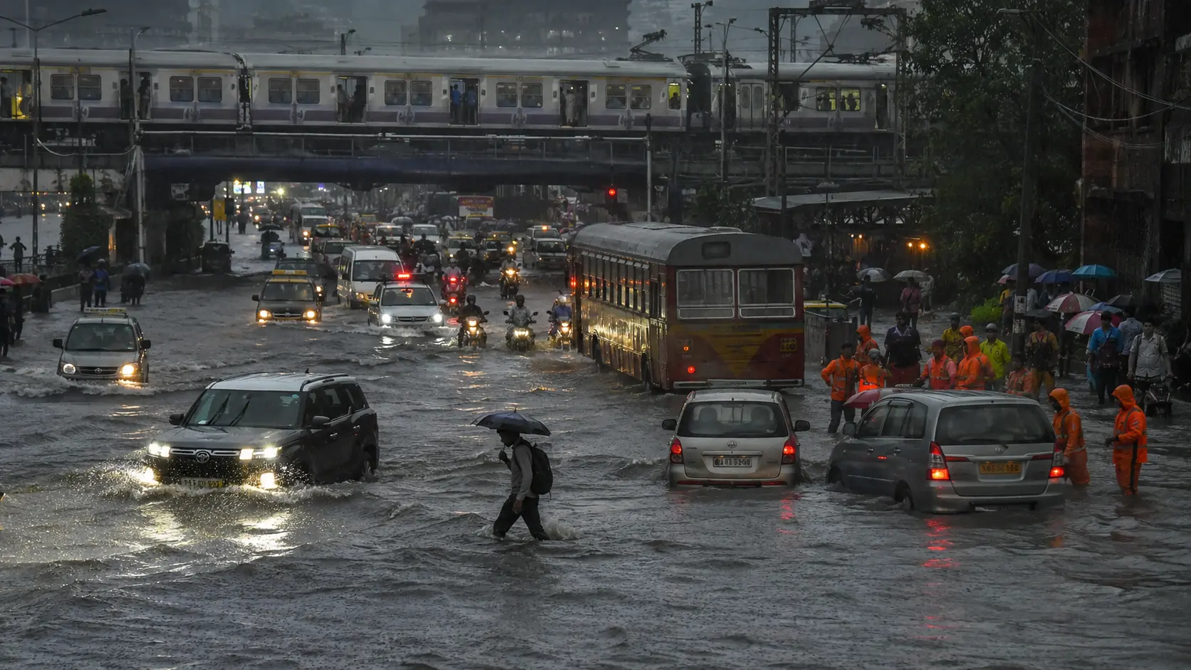 Commuters make their way through flooded streets in Mumbai after heavy monsoon rainfall disrupted transport across the city.