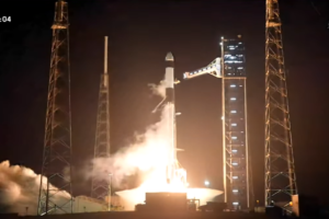 SpaceX Falcon 9 rocket launching Crew-12 mission from Kennedy Space Center at night with bright orange flames and exhaust plume lighting up the launch pad